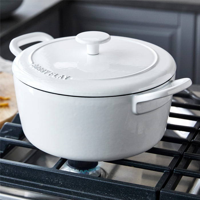 Ivory Dutch oven with lid, 5.5-quart size, ceramic, shown on a stove.