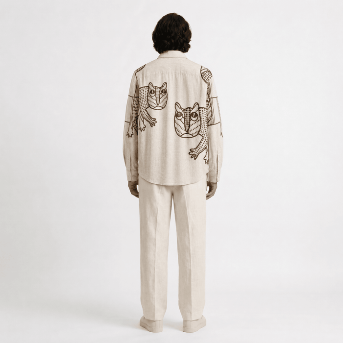 Man wearing the off white Gond Tiger shirt with cream trousers, full length back view