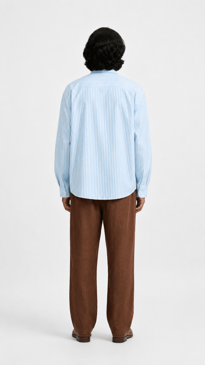 Man wearing the blue striped Kalighat Graffiti shirt with brown trousers, back view