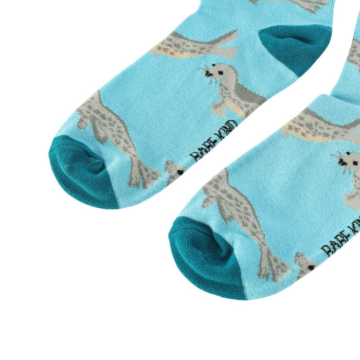 Pair of blue socks with seal pattern on a light blue background