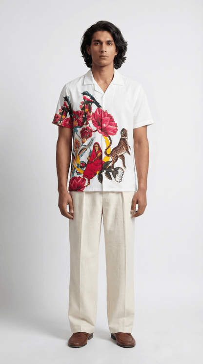 Man wearing the white 16 Bit Retro Art shirt with cream trousers, front view, floral artwork on the left side