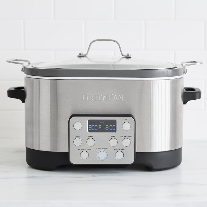 Stainless steel 7-in-1 slow cooker with in-pot browning feature on a white kitchen countertop.