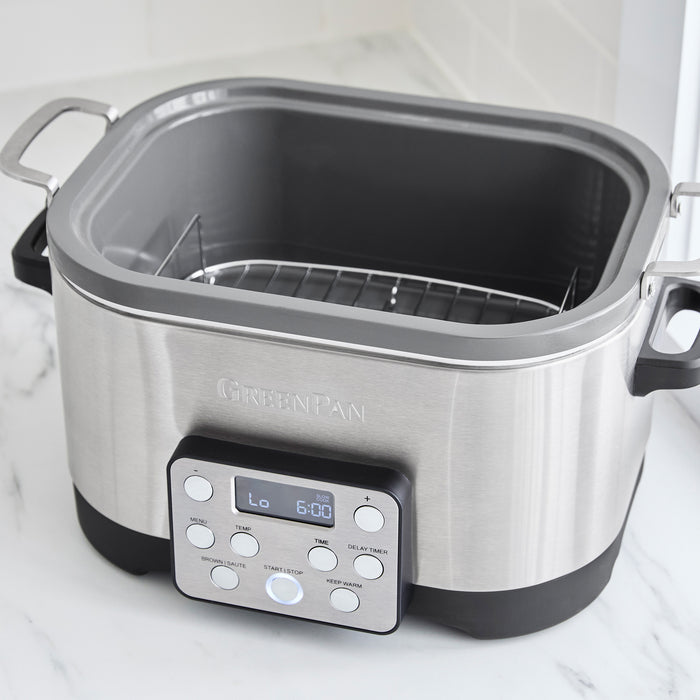 Stainless steel 6-quart slow cooker with in-pot browning on a white countertop.