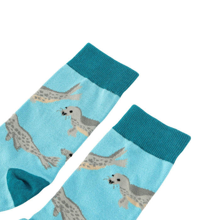Pair of blue socks with seal pattern on a light blue background