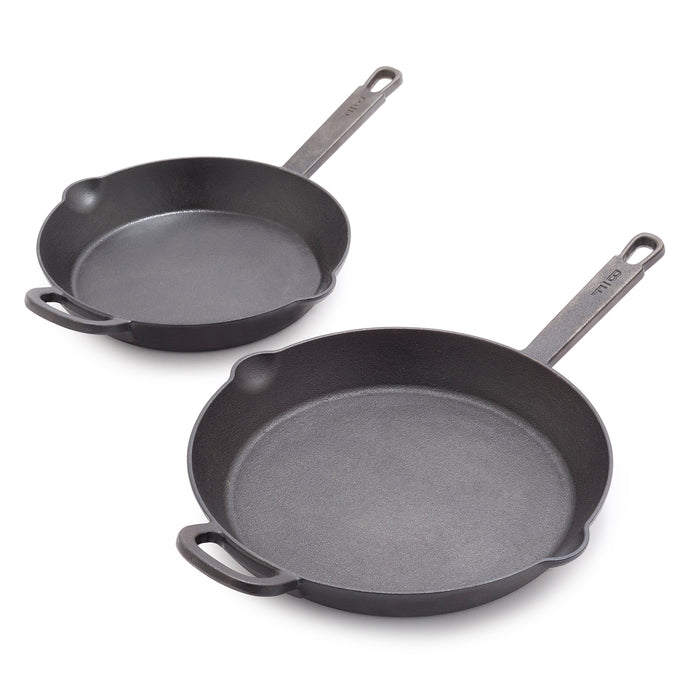 Two black cast iron frypans, 10-inch and 12-inch, displayed side by side as a set.