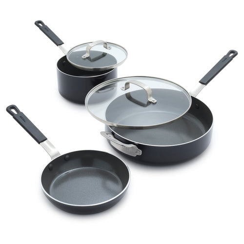 Set of three black ceramic pots and pans with glass lids on a white background.
