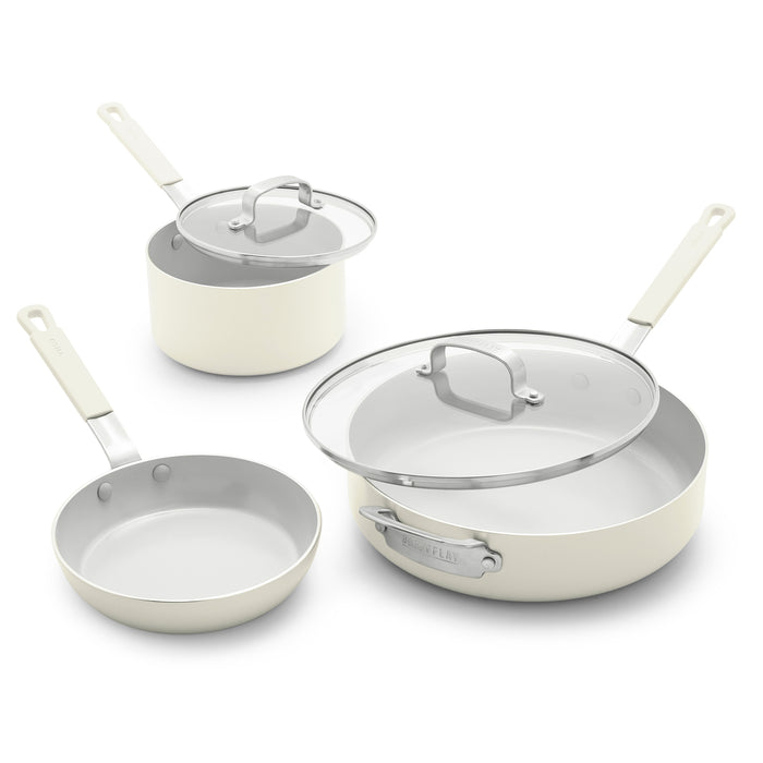 Set of three cream ceramic nonstick pans, two with glass lids, on a white background.