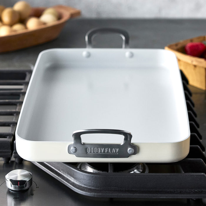 Cream ceramic double burner griddle on a stovetop, 18x11, with Bobby Flay by GreenPan branding.