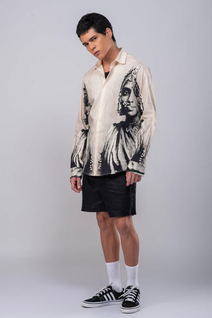Man wearing the CM resort shirt with black shorts, full length three-quarter view, head tilted