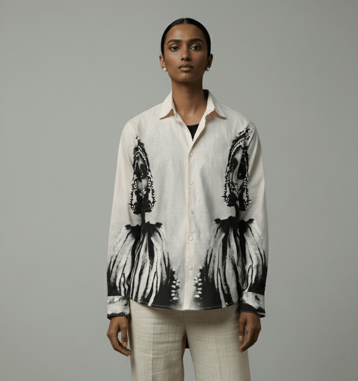 Woman wearing the white and grey CM shirt with cream trousers, front view, portrait print on the lower front