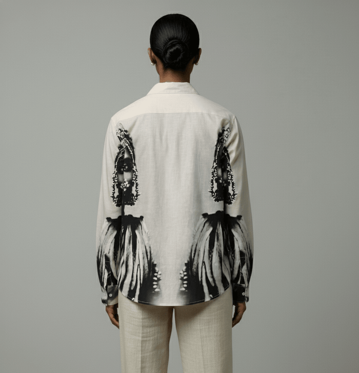 Woman wearing the white and grey CM shirt with cream trousers, back view showing the portrait print