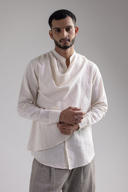 Man wearing the white Cowl shirt with grey trousers, front view, hands held together