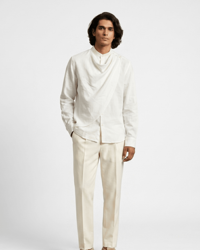 Man wearing the white Cowl shirt with cream trousers, full length front view, hand in pocket
