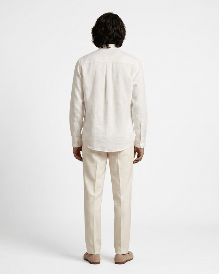 Man wearing the white Cowl shirt with cream trousers, full length back view