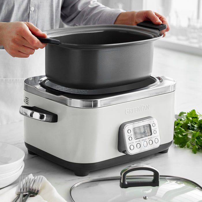 Person removing a pot from a slow cooker