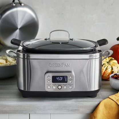 Stainless steel 6-quart slow cooker on a kitchen counter next to pumpkins and a bowl of mashed potatoes.