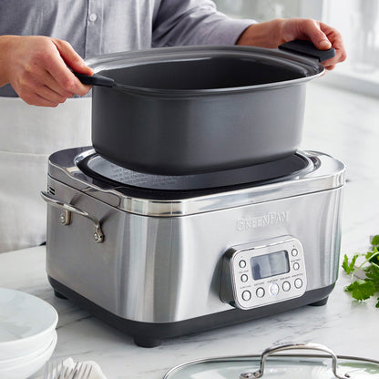 Person removing a pot from a slow cooker