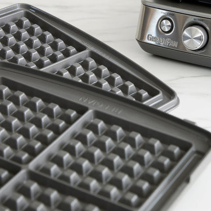 Close-up of two grid-patterned waffle plates for the Elite Ceramic Nonstick 4-Square Waffle Maker | Premiere Stainless Steel, perfect for crafting Liège waffles, shown beside its stainless steel body and control knobs.