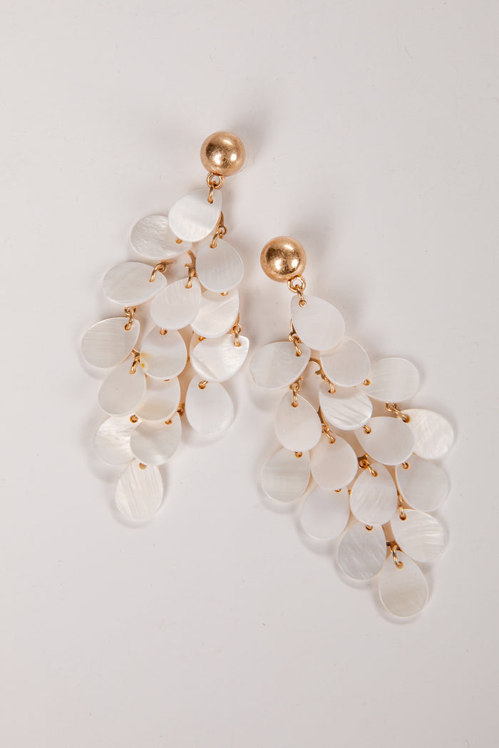 Elegant earrings with white stones and gold accents on a light gray background