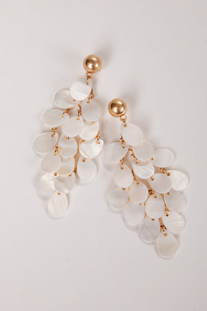 Elegant earrings with white stones and gold accents on a light gray background