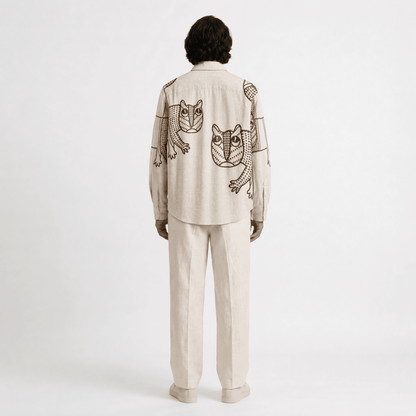 Man wearing the off white Gond Tiger shirt with cream trousers, full length back view