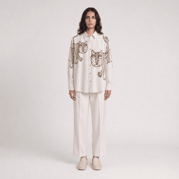 Woman wearing the off white Gond Tiger shirt with white trousers, full length front view