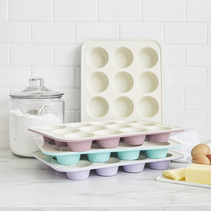 Navy ceramic nonstick muffin pan on a kitchen counter with flour and baking ingredients nearby.