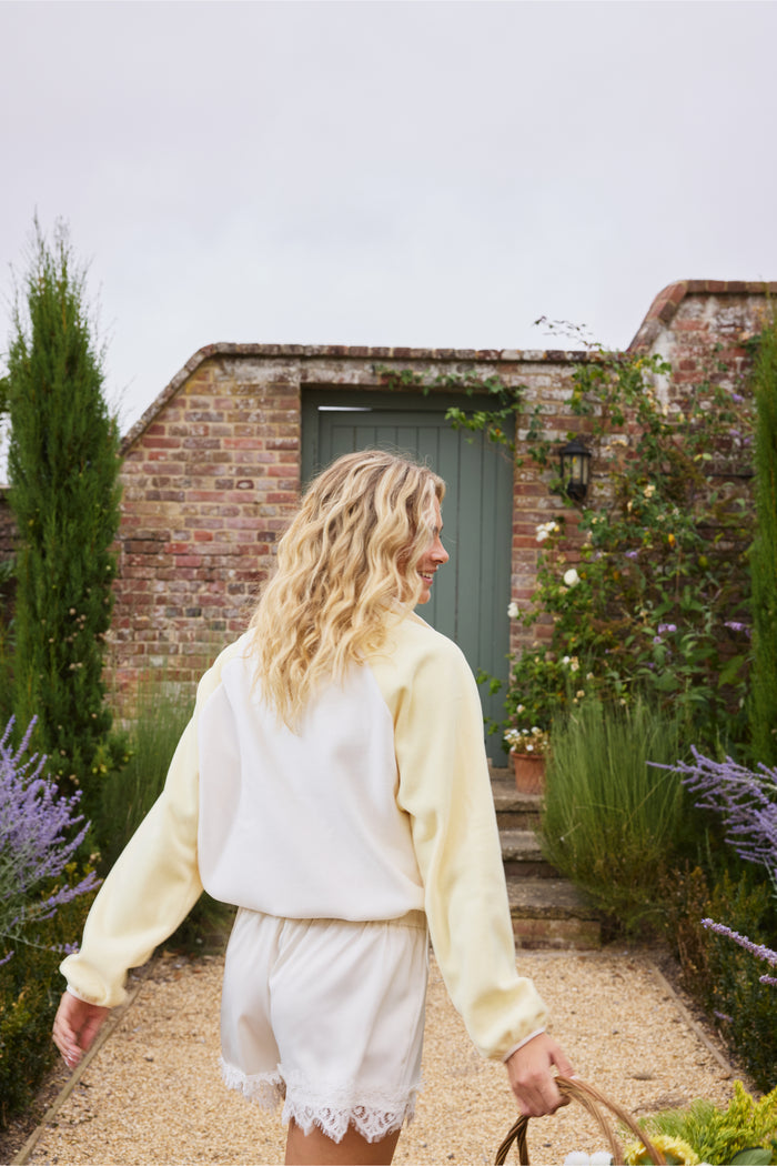 Back view of model wearing Gym+Coffee Snap Polar Fleece Pale Vanilla in garden Shop Gym+Coffee at Dotique
