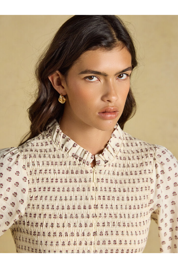 Shop the Joules Zoe Blouse in Cream Ditsy at Dotique. A 100% cotton blouse with a smocked bodice, frill collar, adjustable zip and long sleeves.