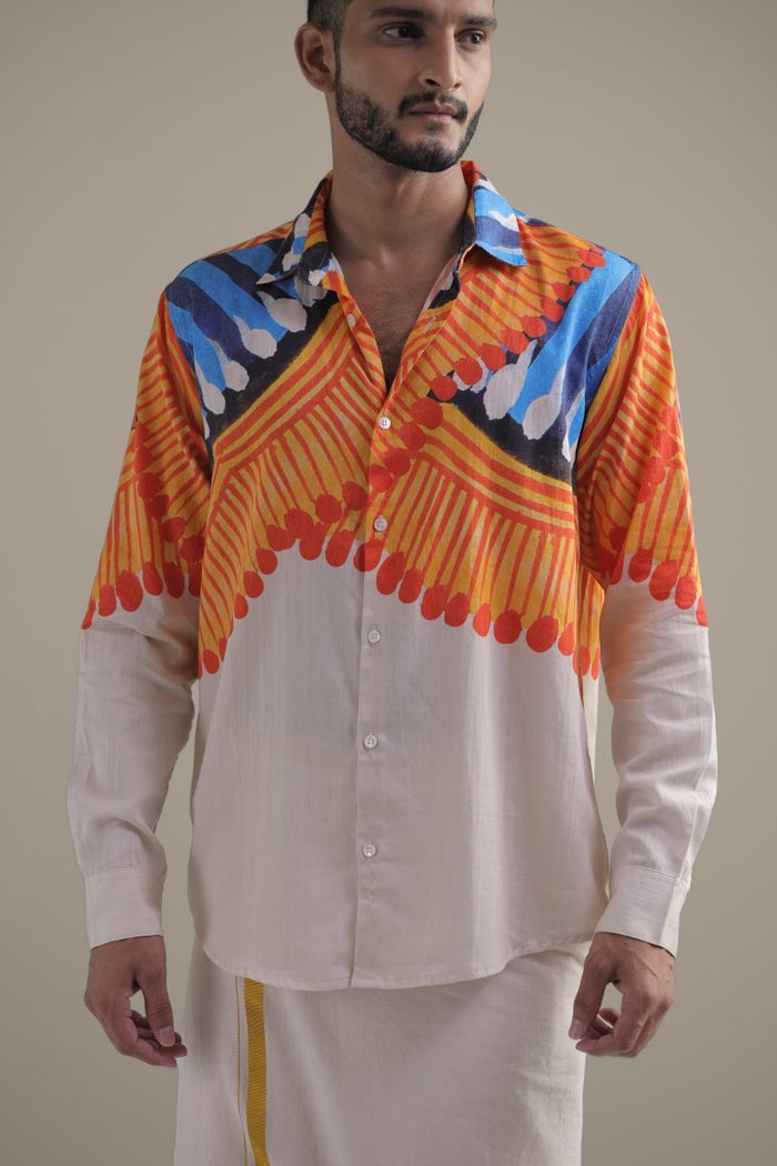 Close view of a man wearing the Kalighat Fire shirt with a white dhoti, front, with orange and blue strokes on the chest