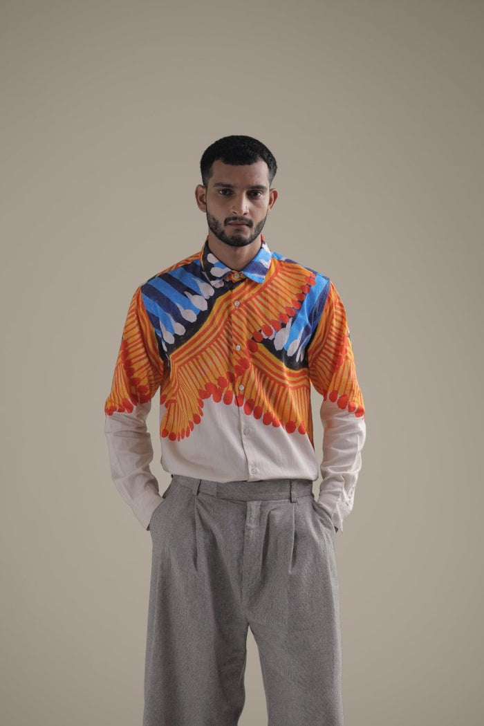 Man wearing the Kalighat Fire shirt with grey trousers, waist-up front view, hands in pockets