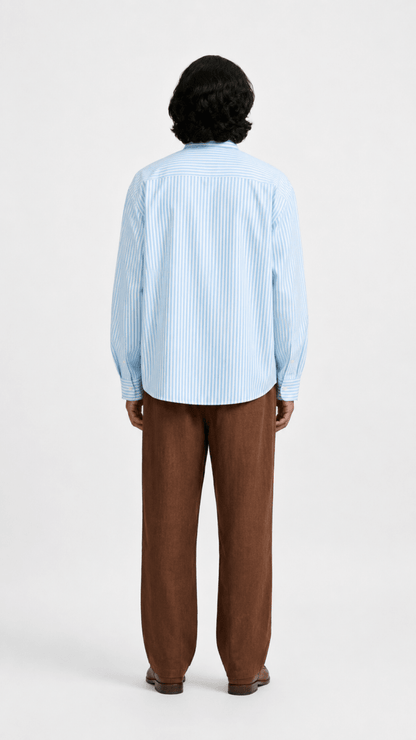 Man wearing the blue striped Kalighat Graffiti shirt with brown trousers, back view