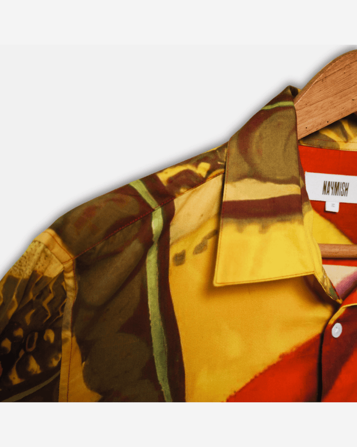 Close view of the Maala shirt collar with the Naymish label and the red and yellow artwork