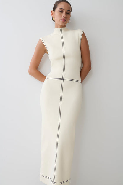 Woman wearing a white dress with black lined accents.