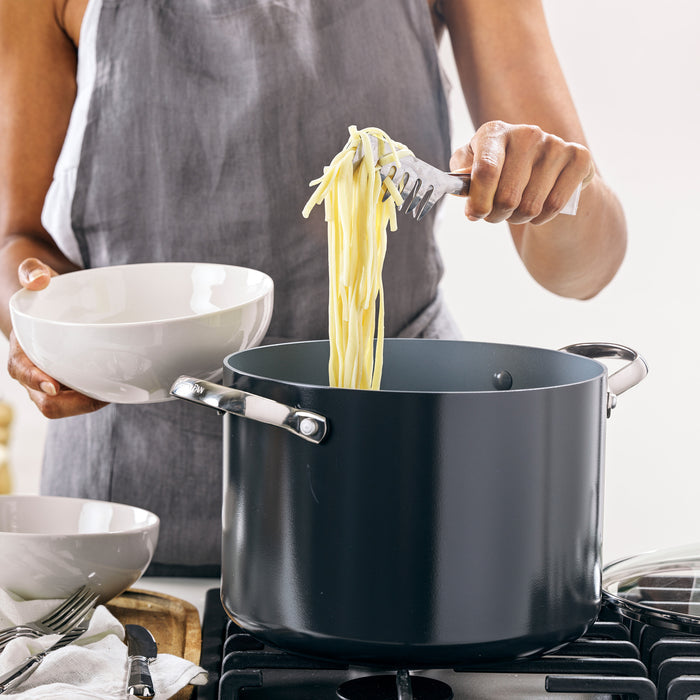 Person using tongs to remove pasta from a stockpot