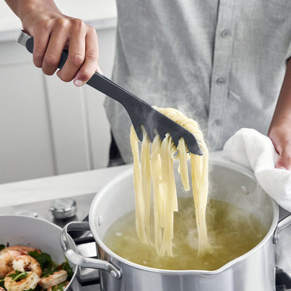 Person using silicone tongs to pull pasta out of a stockpot