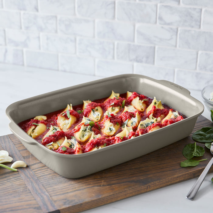 Stuffed pasta shells in tomato sauce with herbs, served in a rectangular white Premiere Ovenware 13x9 baking dish.