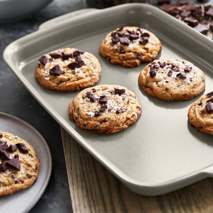 Chocolate chip cookies with sea salt on a taupe ceramic nonstick 4-piece bakeware set.
