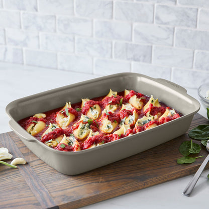 Ceramic taupe Premiere Ovenware 6-piece set with stuffed pasta shells topped with sauce, on a wooden board.