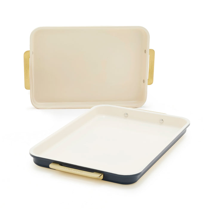 Two-piece quarter sheet pan set with cream interiors and gold handles in a dark twilight blue finish.