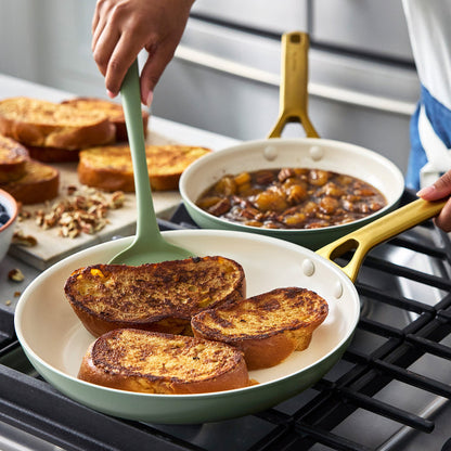 Person cooking French toast in a green pan on a stove