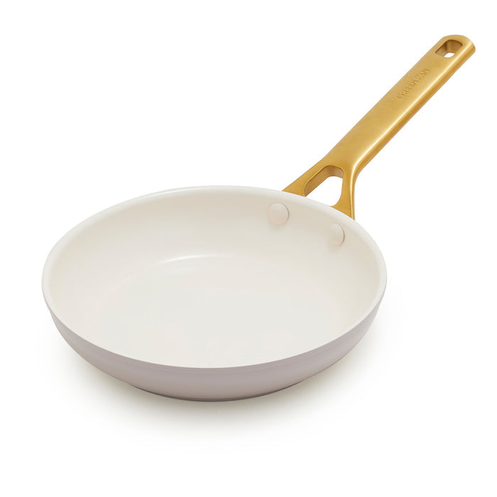 Taupe gray frying pan with a gold handle on a white background