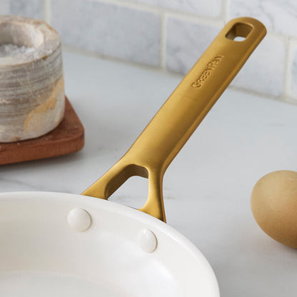 Gold frypan handle on a kitchen counter