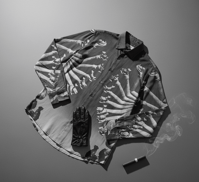 SB Sahasrabahu shirt laid flat with a black glove and a lighter, showing the Hevajra arms artwork