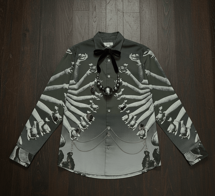SB Sahasrabahu shirt laid flat on a wooden floor with a bow tie and a pearl necklace, front view