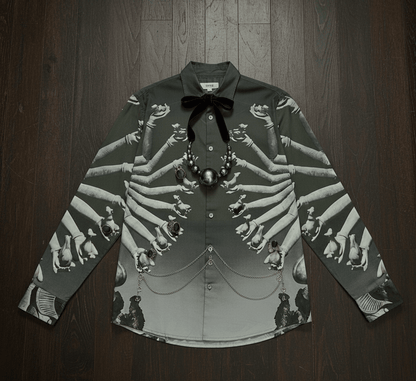 SB Sahasrabahu shirt laid flat on a wooden floor with a bow tie and a pearl necklace, front view