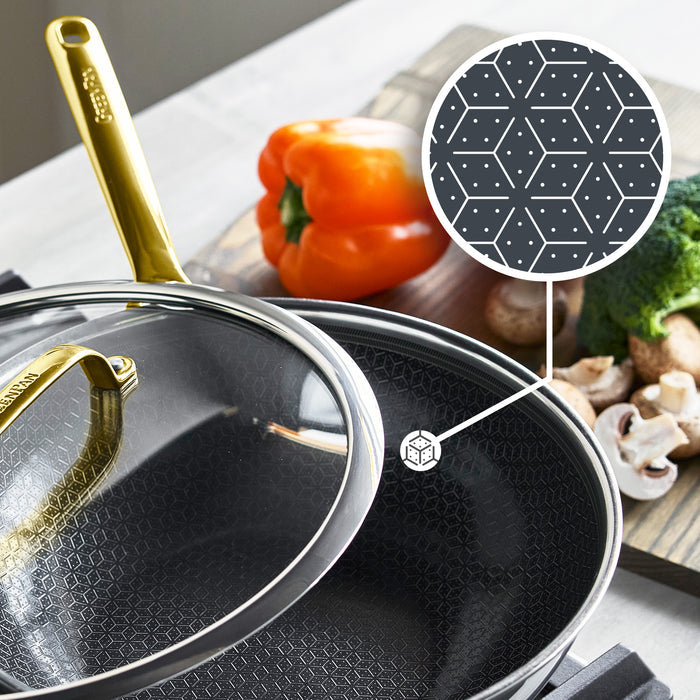 Gold ceramic-coated wok with lid, 12-inch size, displayed with assorted vegetables beside it.