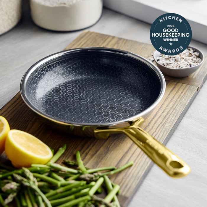 Gold-handle ceramic frypan with vegetables, salt dish, and Good Housekeeping award badge visible.