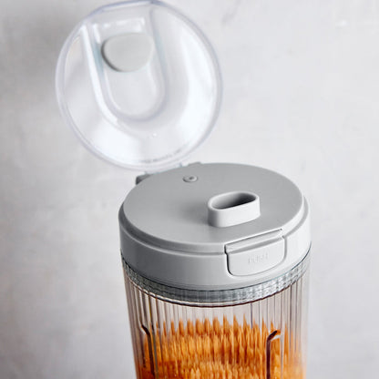 Gray portable blender with a lid on a white background