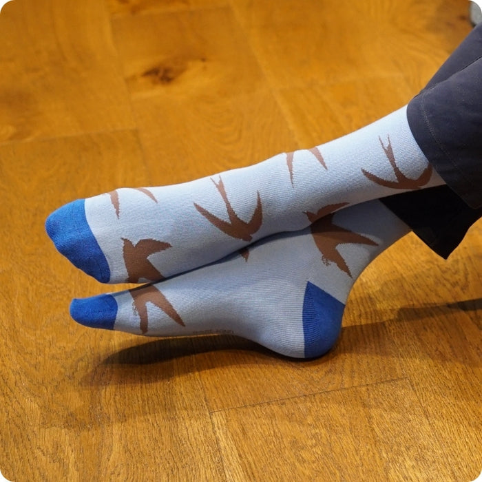 Person wearing swift socks on a wooden floor